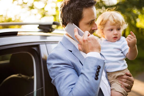 Young-father-with-his-little-boy-and-smartphone-at-the-car